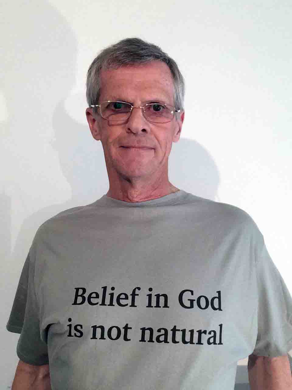 Darwin Bedford wearing a T-shirt simply stating that belief in God is not natural.'