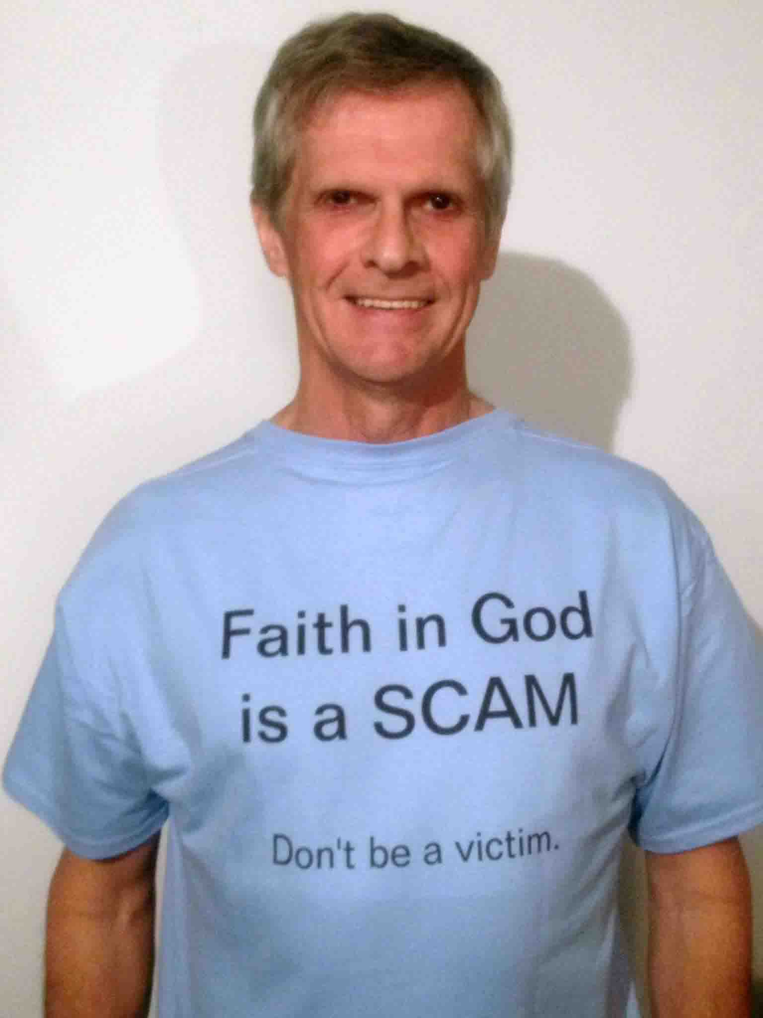 Darwin Bedford wearing his shirt that says 'Faith in God is a Scam -- Don't be a victim'