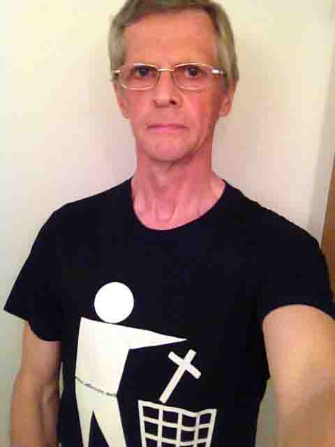 Darwin Bedford wearing a T-shirt depicting the international symbol for a wastes container with a cross in place of the wastes. 